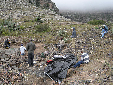 Ein Blick auf Minenarbeiter, die eine Pause in einem Leopardenopal-Minenfeld machen.
